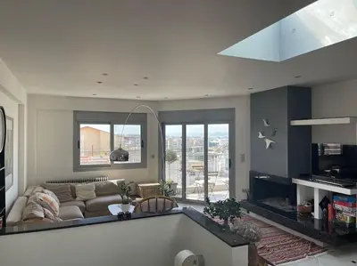 a living room with a couch and a large window at Lovely Maisonette next to Acropolis in Athens