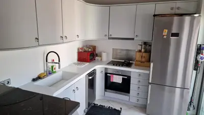 a kitchen with white cabinets and a stainless steel refrigerator at Lovely Maisonette next to Acropolis in Athens