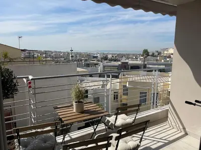 a balcony with a table and chairs on a roof at Lovely Maisonette next to Acropolis in Athens