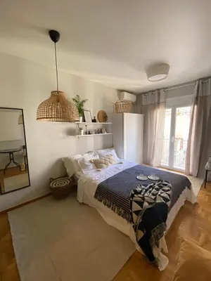 a bedroom with a bed and a large window at City Boho studio in Athens