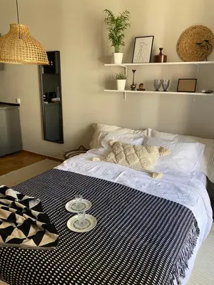a bed with a black and white blanket on it at City Boho studio in Athens
