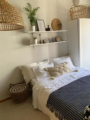a bed in a bedroom with shelves on the wall at City Boho studio in Athens