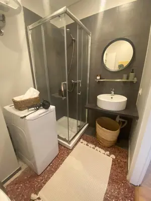 a bathroom with a shower and a toilet and a sink at City Boho studio in Athens