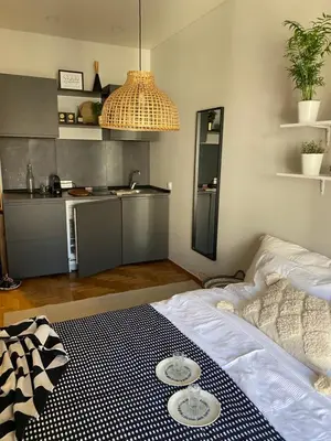a room with a bed and a kitchen with plates on it at City Boho studio in Athens