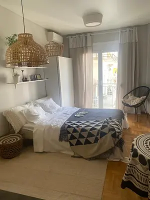 a bedroom with a bed and a table and a window at City Boho studio in Athens