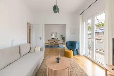 a living room with a white couch and a table at Flawless 1BR Apartment in Athens by UPSTREET in Athens