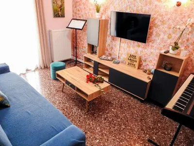 a living room with a blue couch and a television at Green ART House Athens in Athens