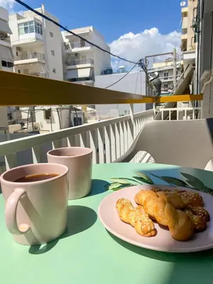 a cup of coffee and a plate of pastries on a table at Green ART House Athens in Athens