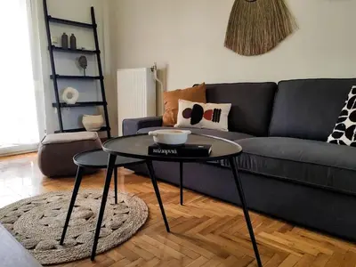 a living room with a couch and a glass table at Funky Boho Kallithea Loft in Athens