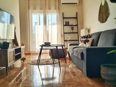 a living room with a blue couch and a table at Funky Boho Kallithea Loft in Athens