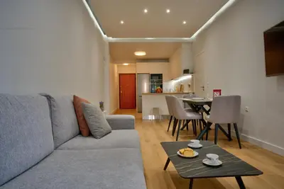 a living room with a couch and a table at The Cosy luxurious Seaside Apartment in Athens