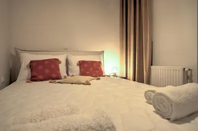a bedroom with a large bed with red pillows at The Cosy luxurious Seaside Apartment in Athens