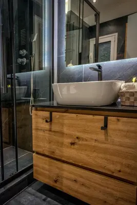 a bathroom with a white sink on a wooden dresser at The Cosy luxurious Seaside Apartment in Athens