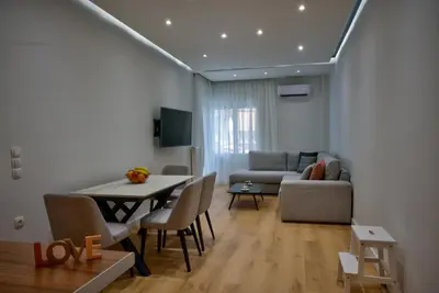 a living room with a table and a couch at The Cosy luxurious Seaside Apartment in Athens