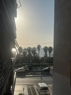 a view of a parking lot with palm trees and the ocean at The Cosy luxurious Seaside Apartment in Athens
