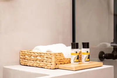 a table with two bottles of shampoo and a basket of towels at Frinichou 18 by Athens Concept Residences in Athens