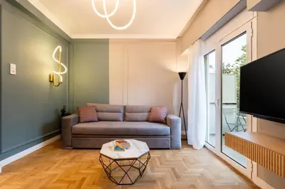 a living room with a couch and a tv at Frinichou 18 by Athens Concept Residences in Athens