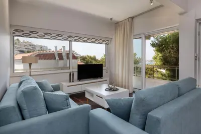 a living room with blue furniture and a large window at Relux Sea View 2 Bedroom Apartment by BluPine in Athens