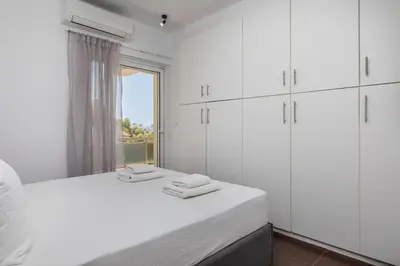 a white bedroom with white cabinets and a window at Relux Sea View 2 Bedroom Apartment by BluPine in Athens