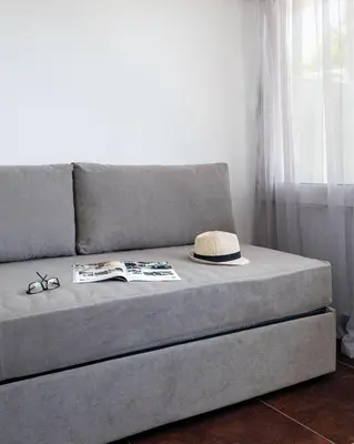 a hat and glasses and a book on a couch at Relux Sea View 2 Bedroom Apartment by BluPine in Athens