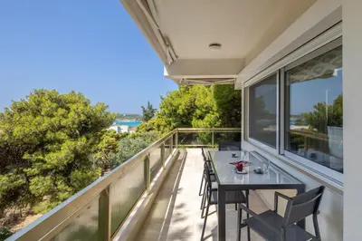 a patio with a table and chairs on a balcony at Relux Sea View 2 Bedroom Apartment by BluPine in Athens