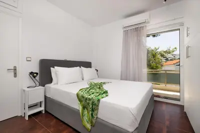 a white bedroom with a bed and a window at Relux Sea View 2 Bedroom Apartment by BluPine in Athens