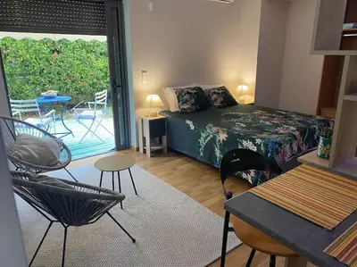 a bedroom with a bed and chairs and a patio at Studio for a couple in Athens