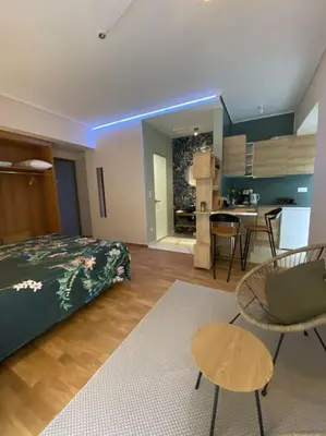 a bedroom with a bed and a table and a kitchen at Studio for a couple in Athens