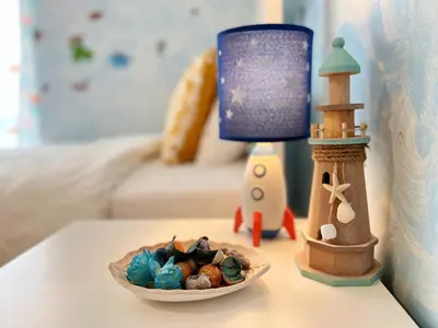 a table with a bowl of shells and a lighthouse at Cozy fairytal garden apartment, Family Friendly, Free parking, 15 Min to Airport in Athens