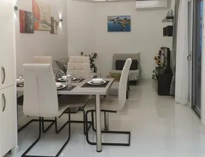 a dining table and chairs in a living room at Keti's home in Athens