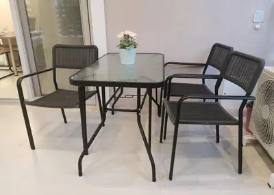 a glass table with four chairs and a vase with flowers at Keti's home in Athens