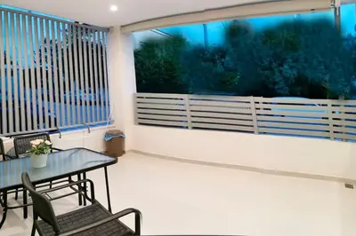 a balcony with a table and chairs and a large window at Keti's home in Athens