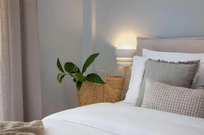 a bedroom with a white bed with a plant on it at The Southern Mansion Athens in Athens