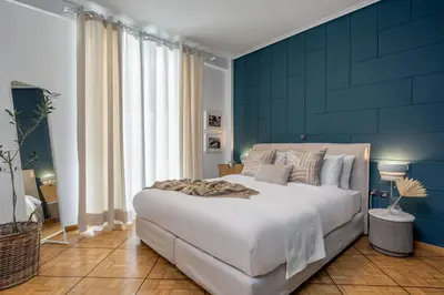 a bedroom with a large bed with a blue wall at The Southern Mansion Athens in Athens