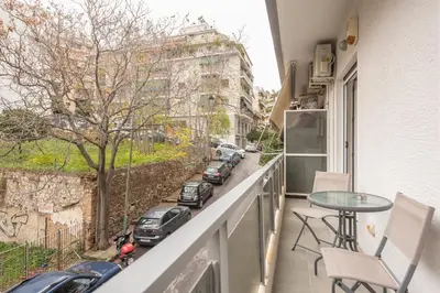 a balcony with a table and chairs and a street at Supreme Athens Home by Cloudkeys in Athens