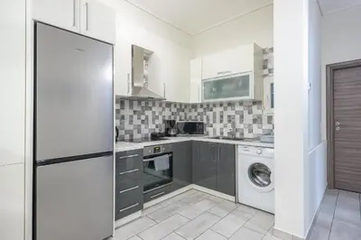 a kitchen with a washing machine and a washer at Supreme Athens Home by Cloudkeys in Athens