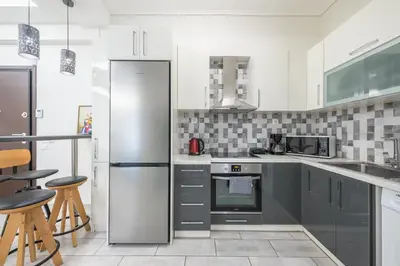 a kitchen with a stainless steel refrigerator and cabinets at Supreme Athens Home by Cloudkeys in Athens