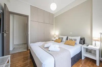 a bedroom with a large white bed with towels on it at Supreme Athens Home by Cloudkeys in Athens
