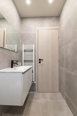 a bathroom with a sink and a wooden door at Greyt Apartments Glyfada in Athens