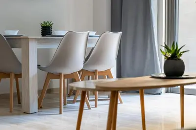 a dining room table with white chairs and a wooden table at Greyt Apartments Glyfada in Athens