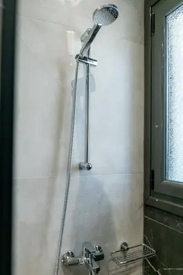 a shower in a bathroom with two faucets at Greyt Apartments Glyfada in Athens