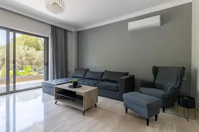 a living room with a couch and two chairs and a table at Greyt Apartments Glyfada in Athens