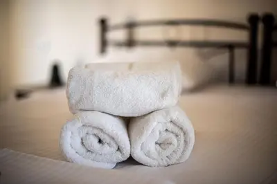 a pile of towels sitting on top of a bed at Elia Apartments in Agia Marina Aegina