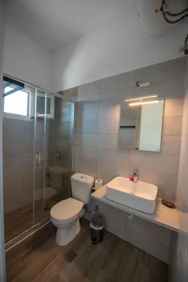 a bathroom with a toilet and a sink and a shower at Elia Apartments in Agia Marina Aegina