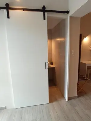 an open white door in a room with a table at Elia Apartments in Agia Marina Aegina