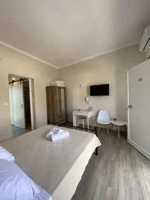 a bedroom with a large bed and a flat screen tv at Elia Apartments in Agia Marina Aegina