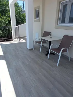 a patio with two chairs and a table on a balcony at Elia Apartments in Agia Marina Aegina