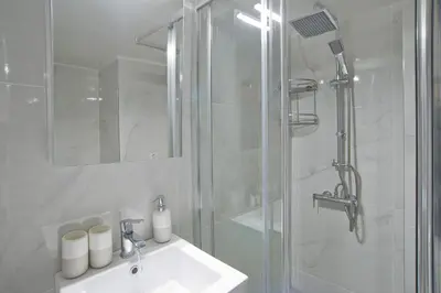 a white bathroom with a shower and a sink at Sofia's Home Piraeus Modern, Reno, Fully Equipped in Piraeus