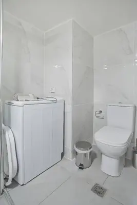 a white bathroom with a toilet and a sink at Sofia's Home Piraeus Modern, Reno, Fully Equipped in Piraeus