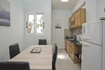 a kitchen with a table and a refrigerator at Sofia's Home Piraeus Modern, Reno, Fully Equipped in Piraeus